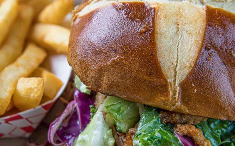 Pulled pork sandwich on a pretzel bun served at Wide Open Saloon in Sedalia