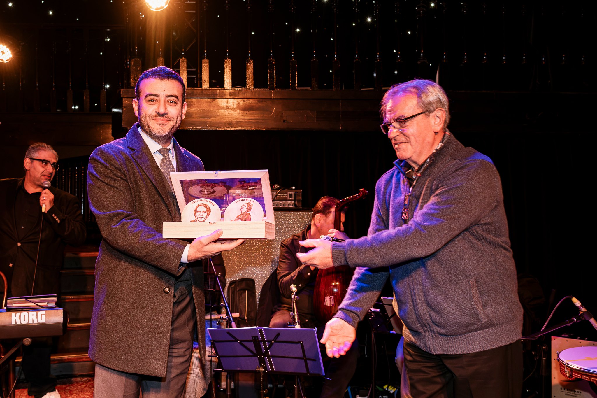 Mr Tannous Kabiity, the Consul-General of Lebanon in Victoria, accepting a gift of wooden artwork of Um Kulthoum and Halim; presented by Krikor Khaderian on behalf of Tarab Ensemble.