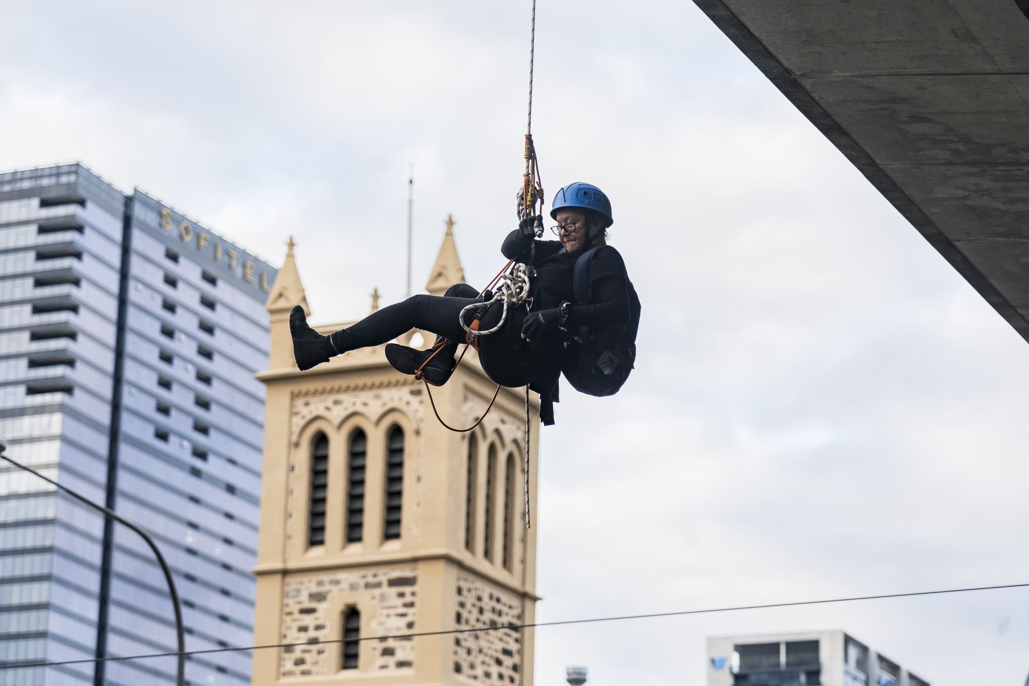 Meme Thorne of Extinction Rebellion South Australia abseils off the Morphett St bridge in Central Adelaide. Photo: Matt Hrkac
