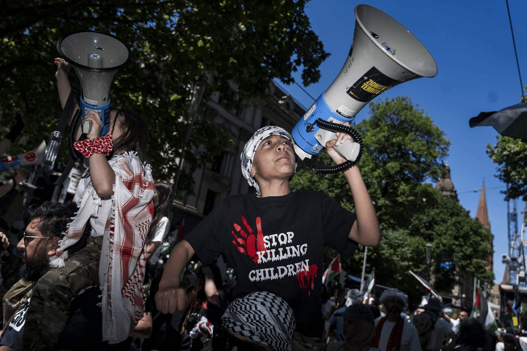 A young boy leads chants at a pro Palestine rally in Melbourne. Photo: Matt Hrkac