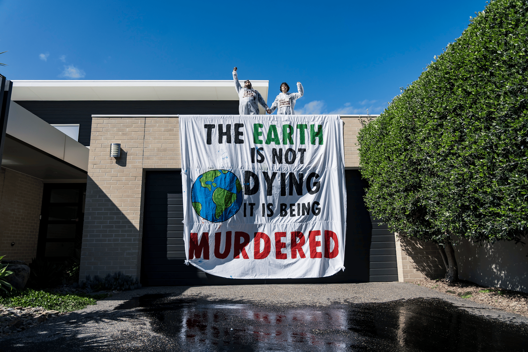 Protesters occupy the rooftop of the home of Viva Energy CEO Scott Wyatt