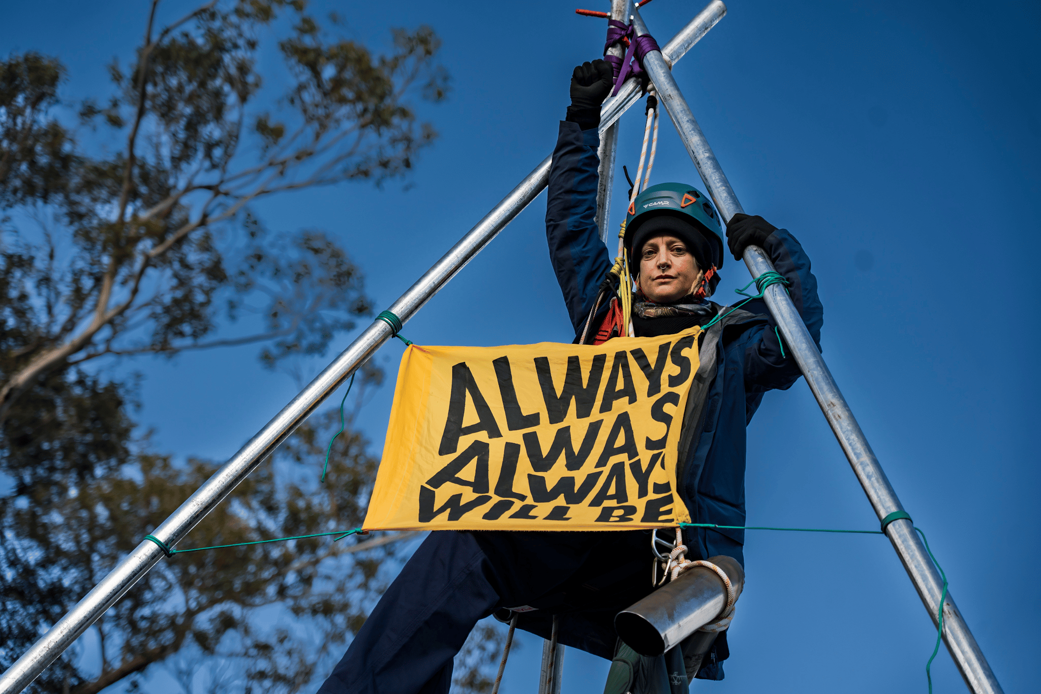A protester suspends themselves atop a tripod on Punt Road Bridge in solidarity with Gunditjmara People opposed to seismic blasting