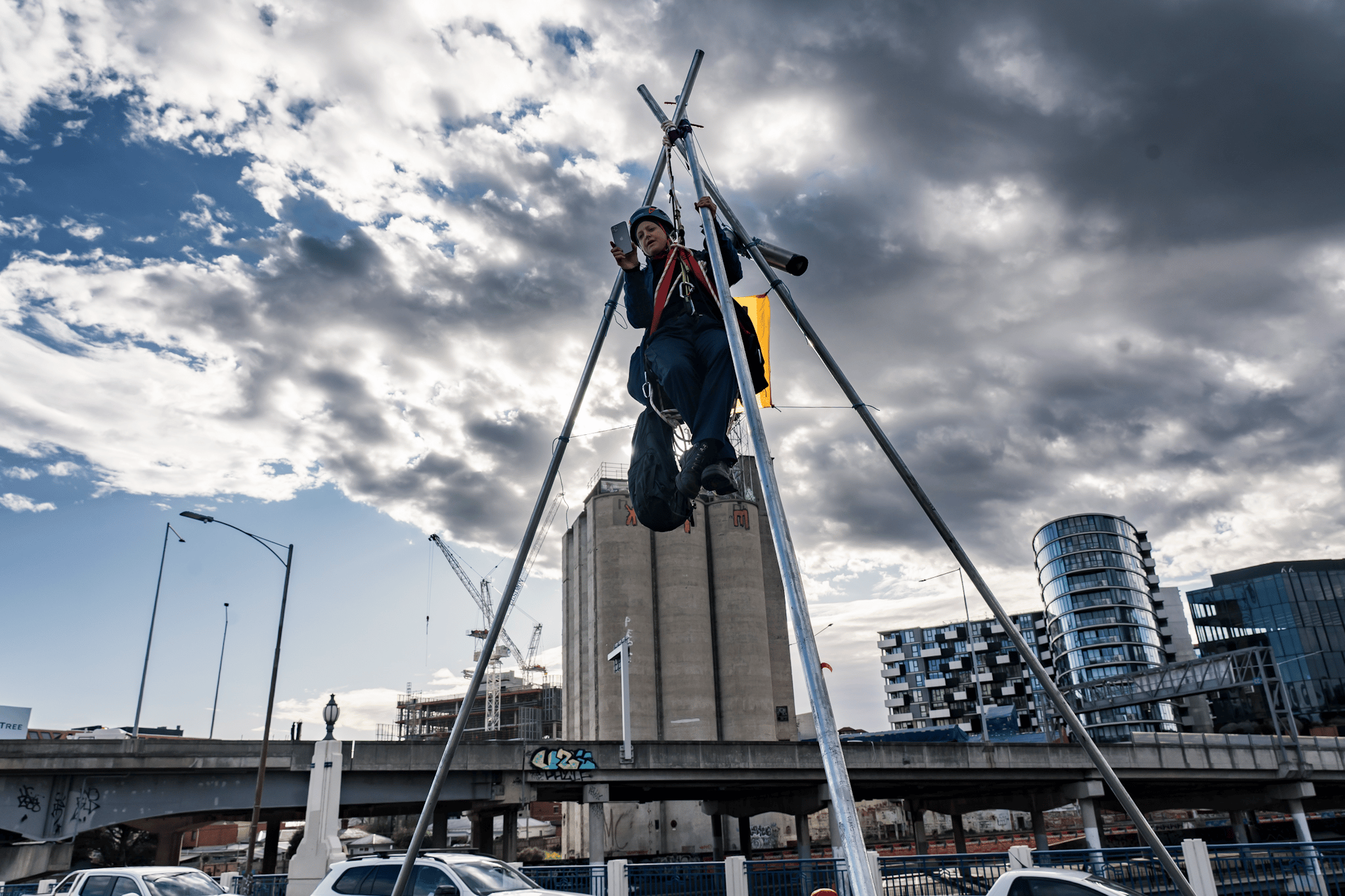 A protester suspends themselves atop a tripod on Punt Road Bridge in solidarity with Gunditjmara People opposed to seismic blasting
