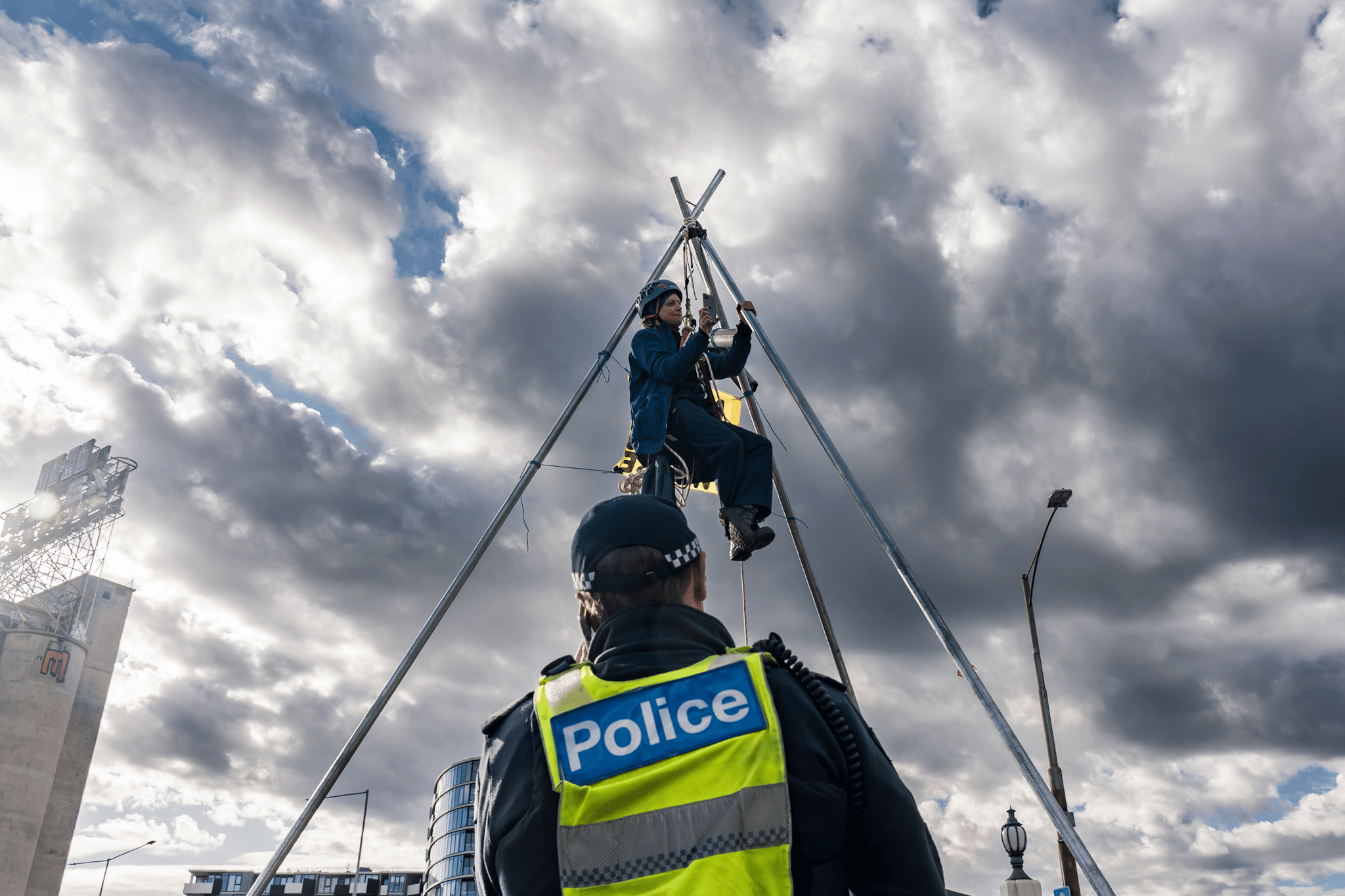 A protester suspends themselves atop a tripod on Punt Road Bridge in solidarity with Gunditjmara People opposed to seismic blasting