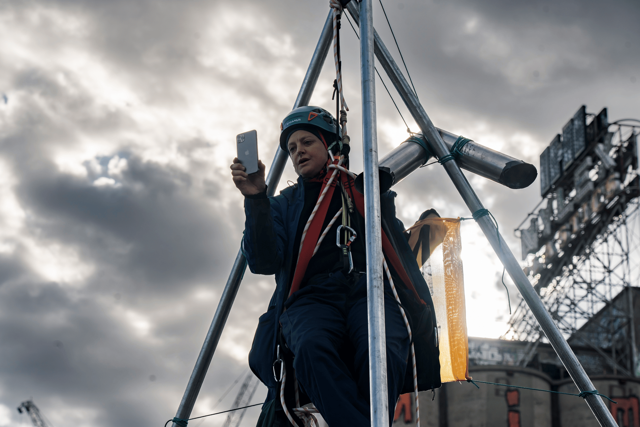 A protester suspends themselves atop a tripod on Punt Road Bridge in solidarity with Gunditjmara People opposed to seismic blasting