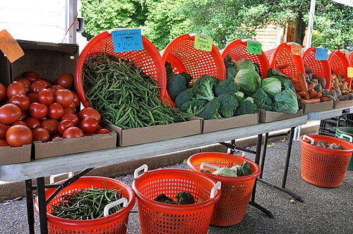 A small, soft photo of vegetables at a market stall