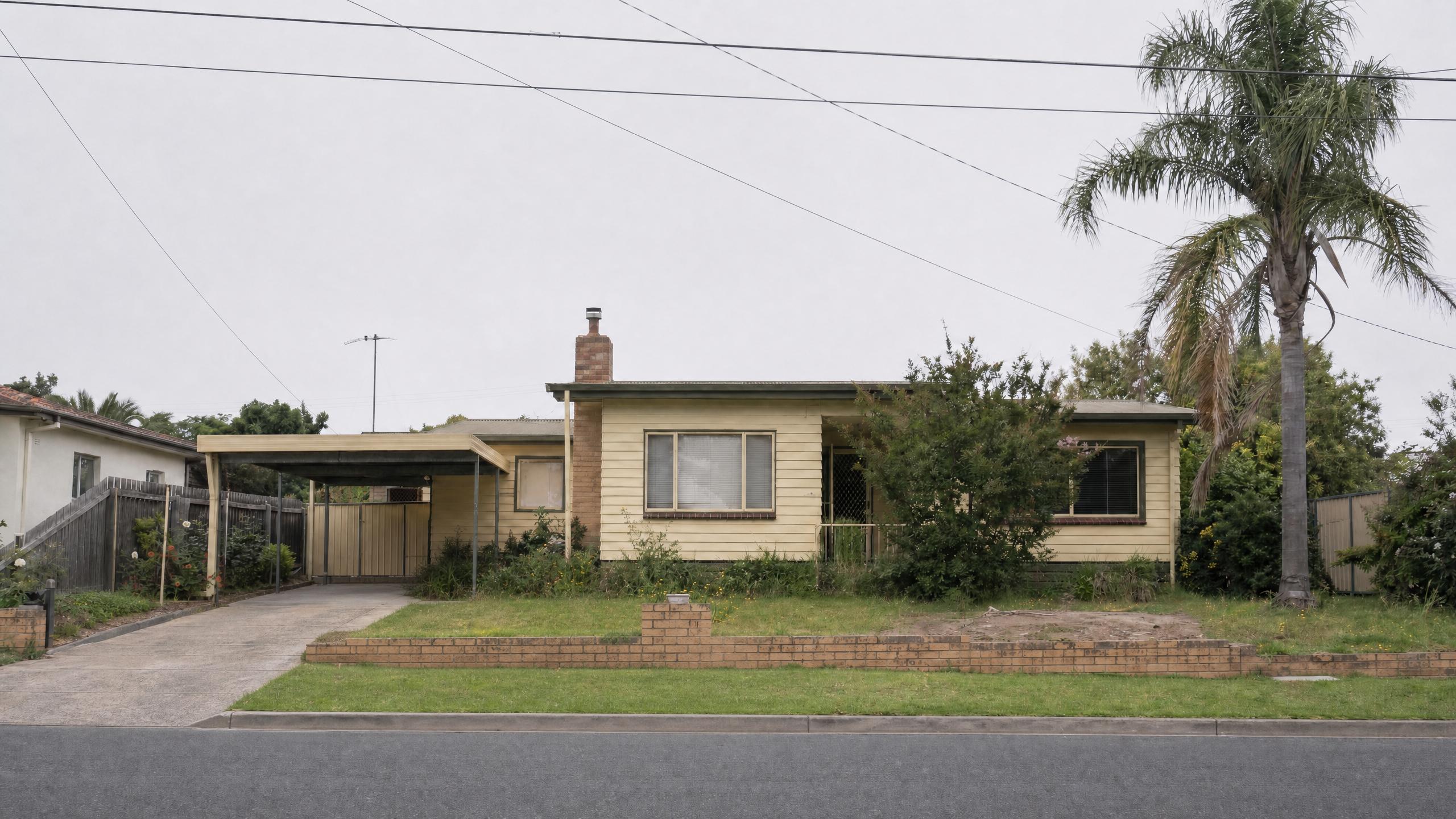 The same yellow weatherboard house under an overcast sky with the parked car and bin removed