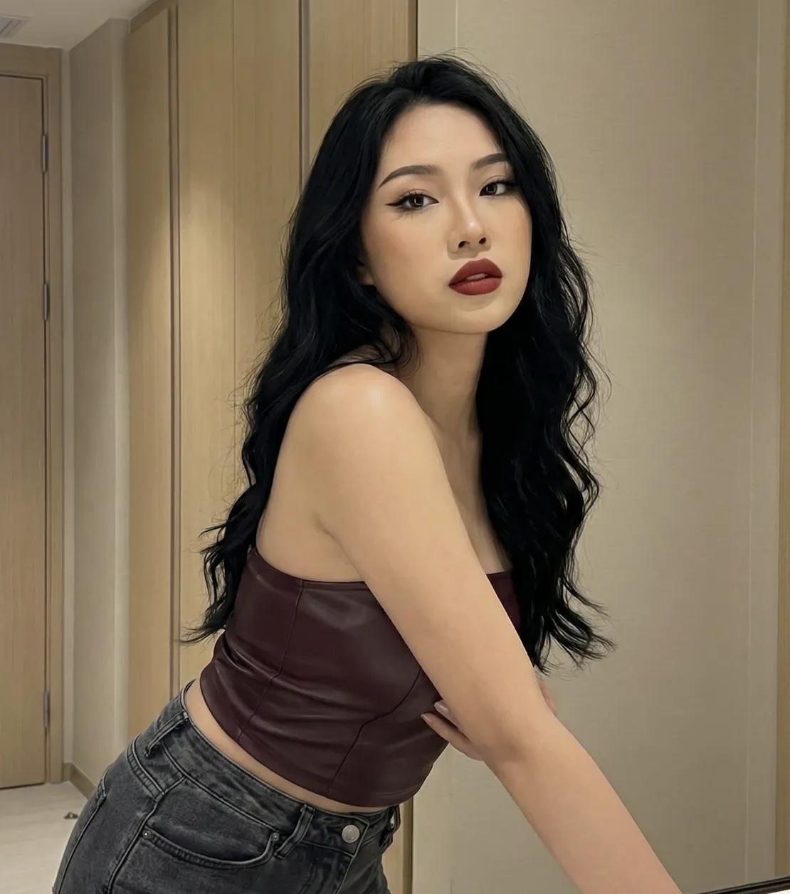 A woman with long black hair wearing a leather top