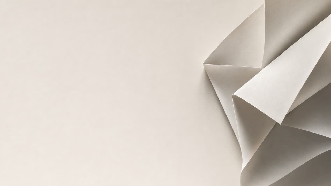 Folded white paper sculpture on the right edge of a plain off-white background