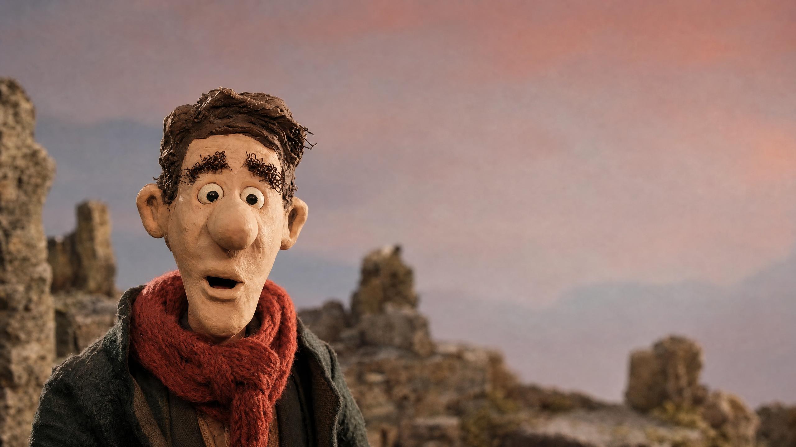 Claymation man in a red knit scarf talking in front of rocky ruins under a pink sky