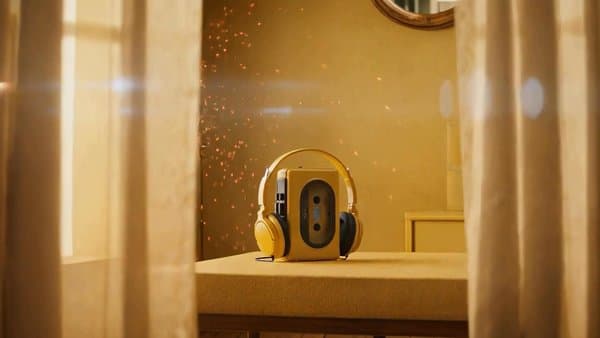 Retro cassette player with headphones on a sunlit dresser, dust in the light