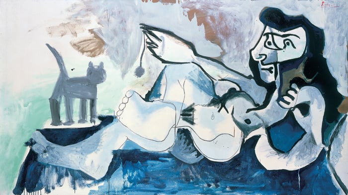 Femme nue couchée jouant avec un chat