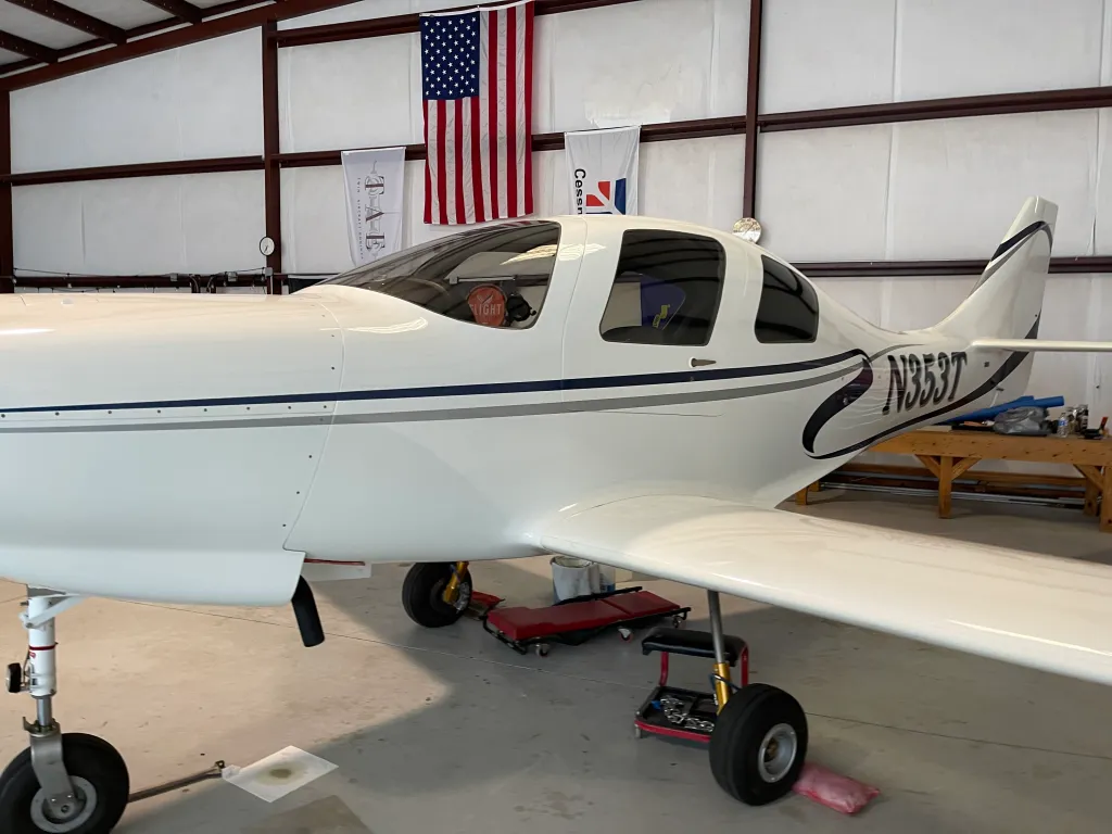 Side profile of a tinted airplane in a hangar