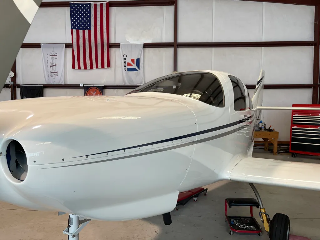 Front view of a tinted airplane in a hangar with American flag