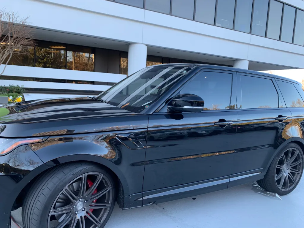 Black Range Rover with premium window tint parked in front of an office building