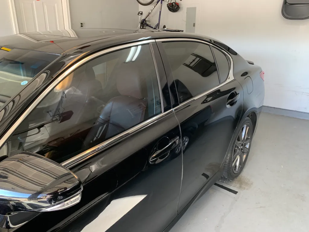 Lexus GS sedan with professional window tinting in a garage