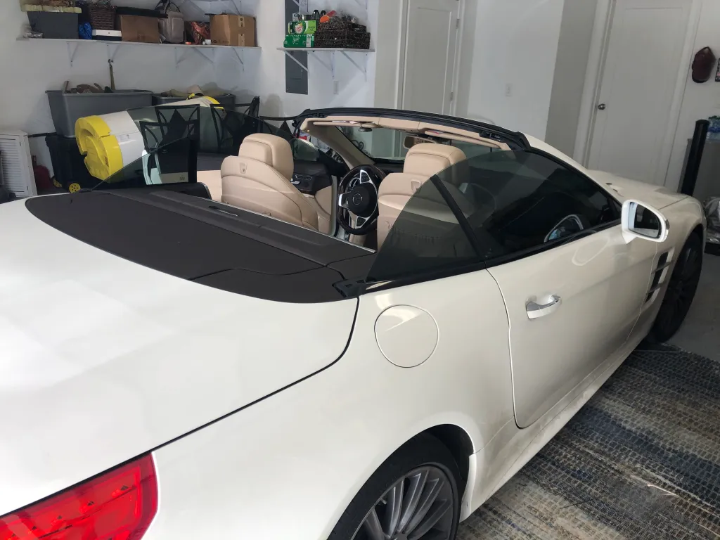 White Porsche convertible with professional window tinting in garage