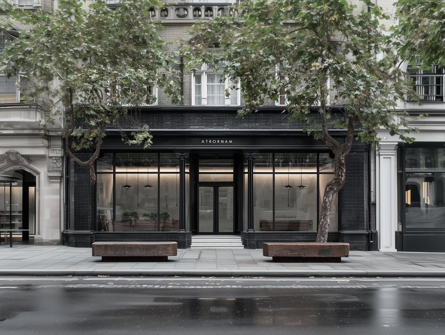 Sleek black storefront with large glass windows, street trees, and two wooden benches.