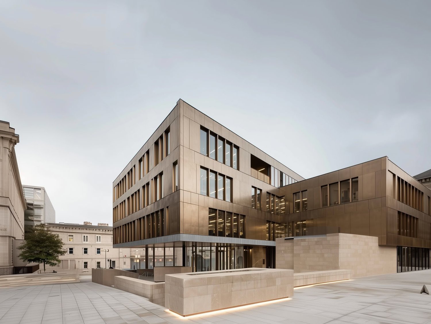 Modern building with bronze facade and large windows in an urban square.