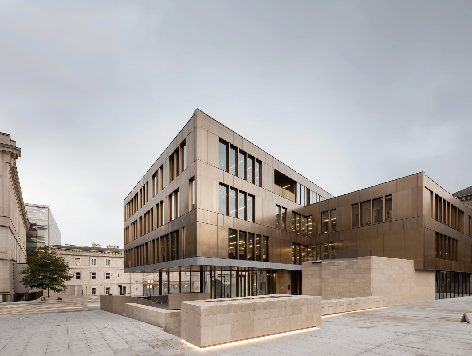 Modern building with bronze facade and large windows in an urban square.