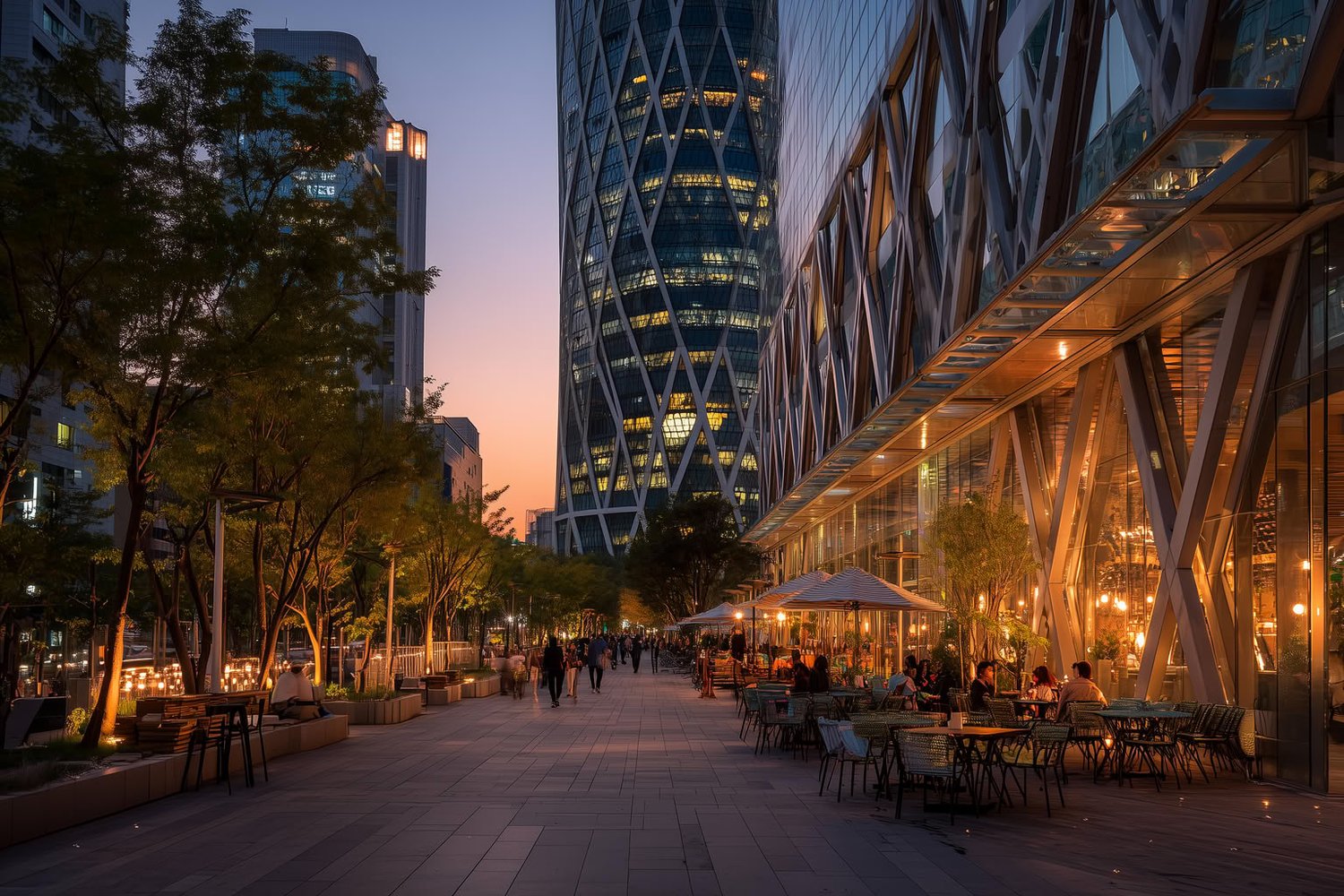 Modern urban promenade at dusk with illuminated high-rises and outdoor dining.