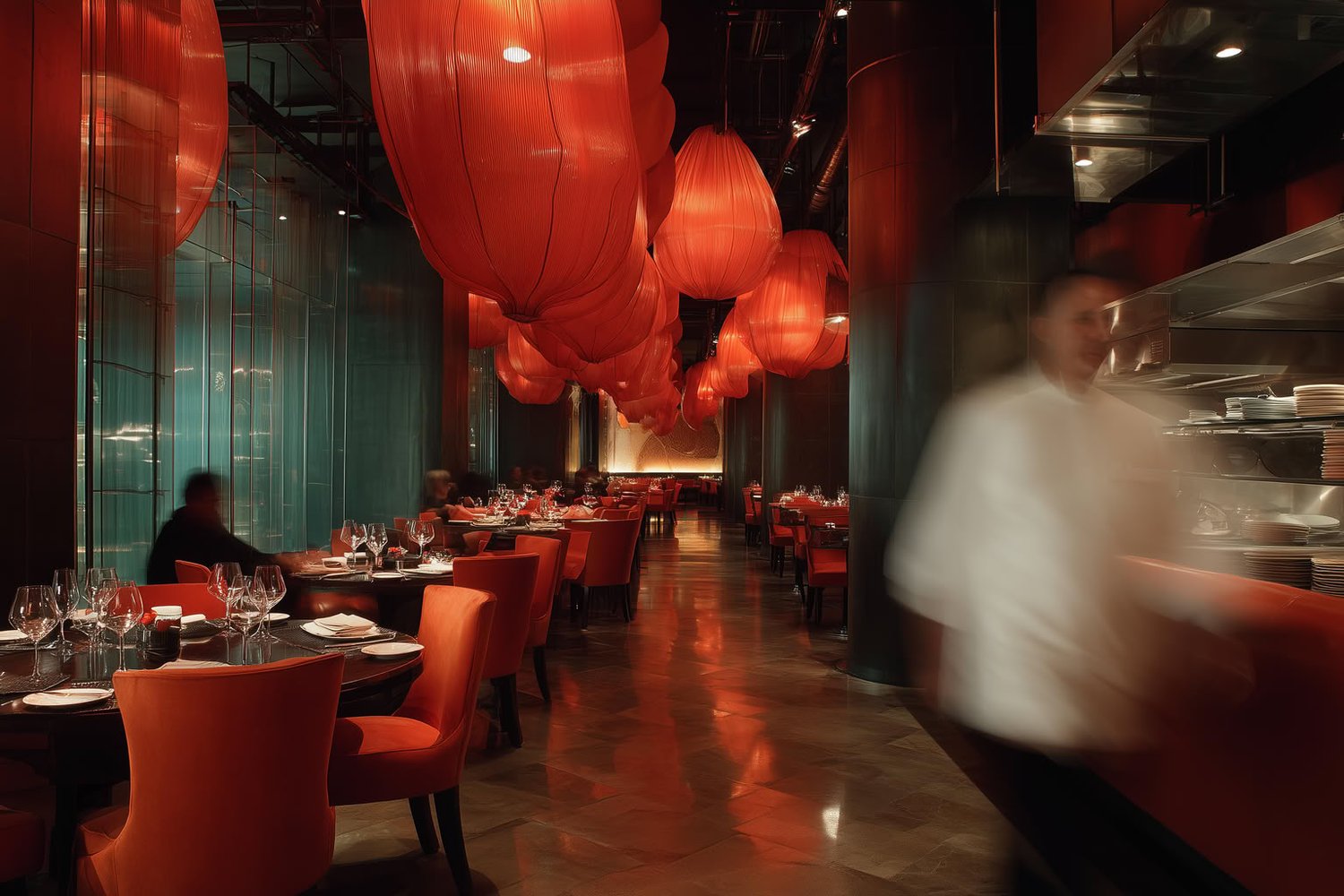 Modern restaurant interior with red lanterns, orange chairs, and a blurred chef.