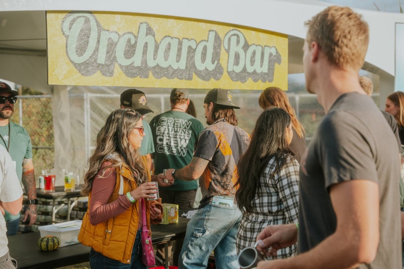 Guests enjoying drinks at the Orchard Bar during the 2 Towns Ciderhouse Harvest Party 2025.