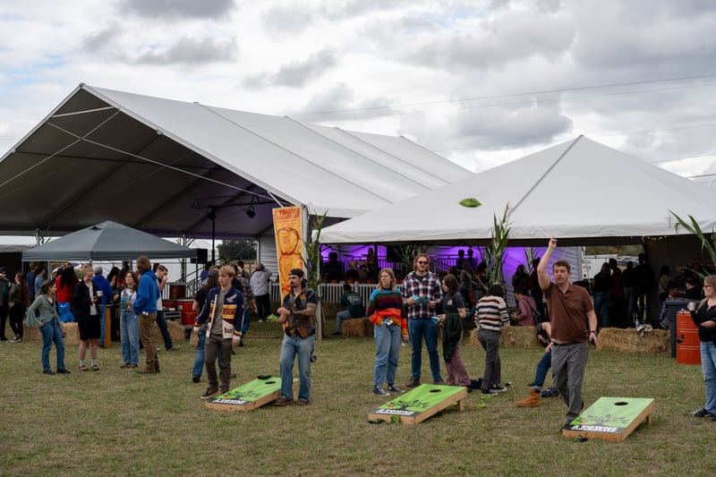 Participants enjoying cornhole at the 2 Towns Ciderhouse Harvest Party 2025.