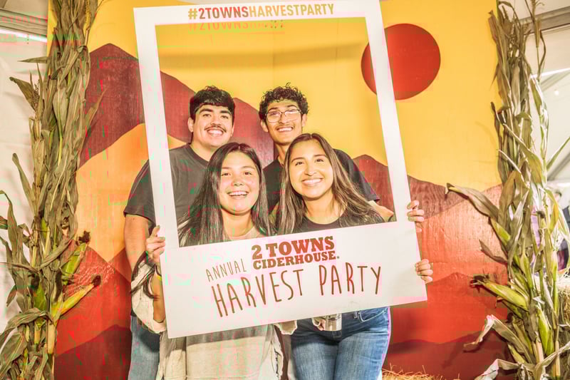 Participants posing in a photo booth at Harvest Party 2024.