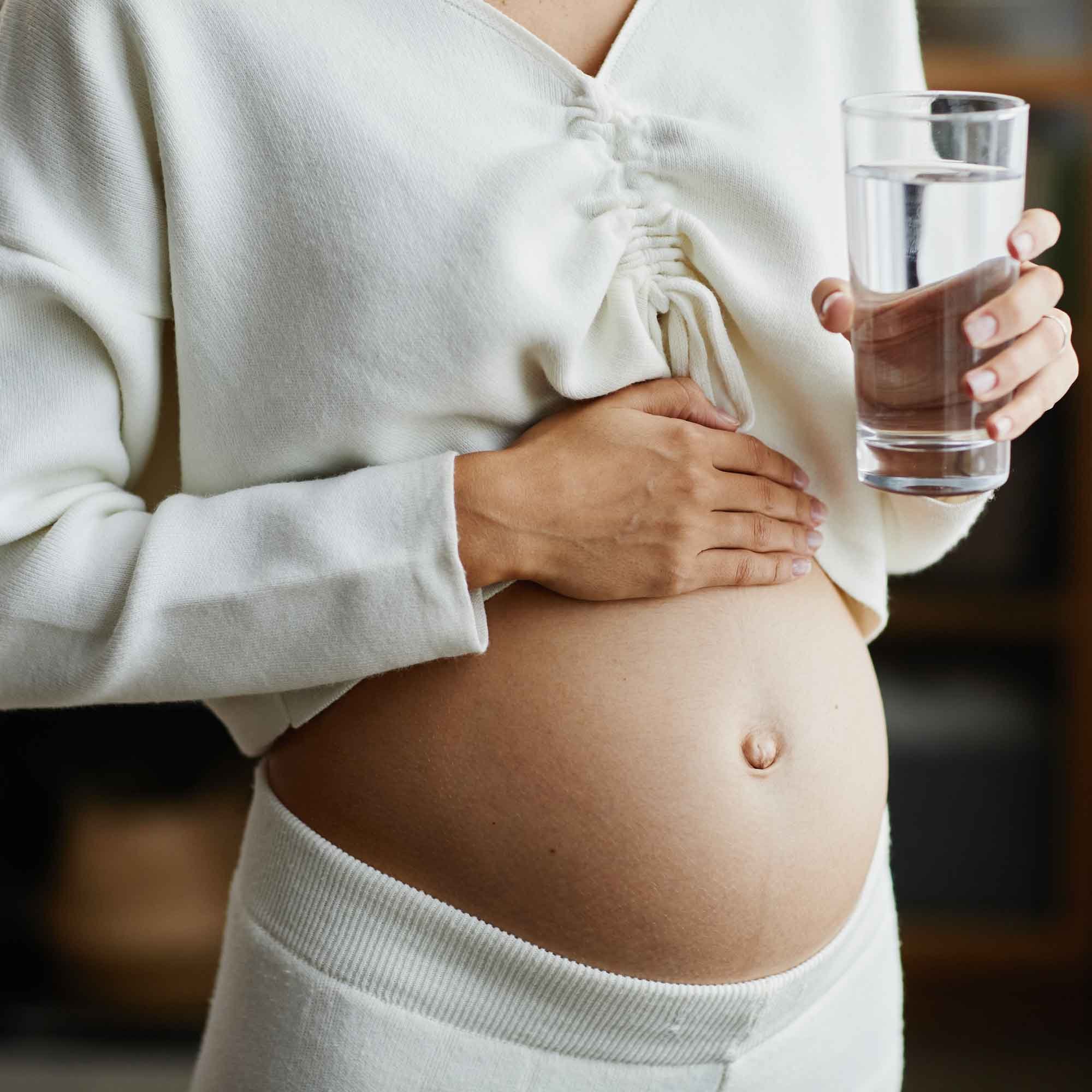 Schwangere Frau trinkt Wasser