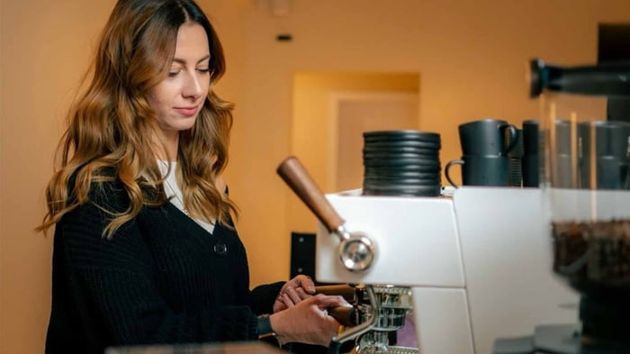 Frau an einer Kaffeemaschine