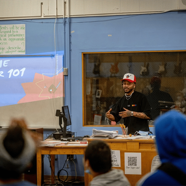 Teacher presenting in a classroom with students, using visuals created by school poster printers