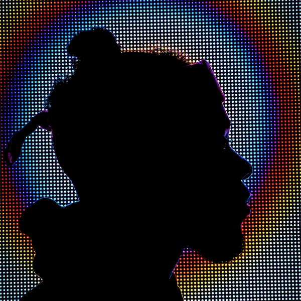 Silhouette of a person against a colorful pixelated background
