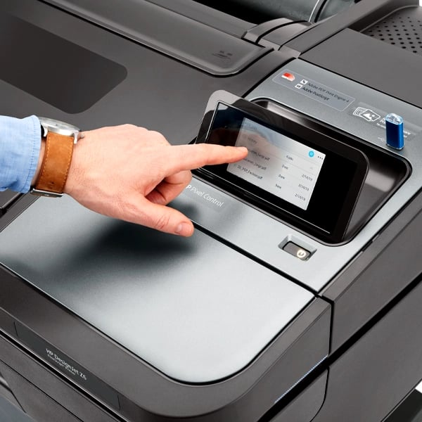 A person adjusting settings on a Poster Studio Express poster maker touchscreen, preparing to print a poster