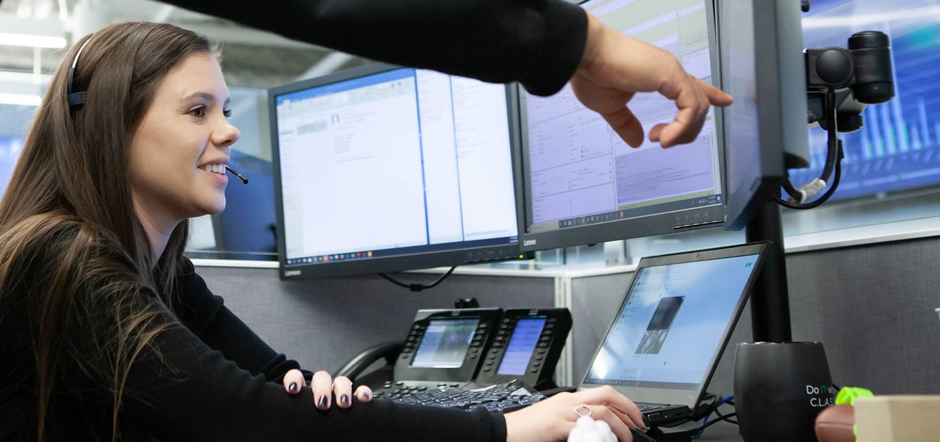 centrexIT support team member at help desk with multiple monitors