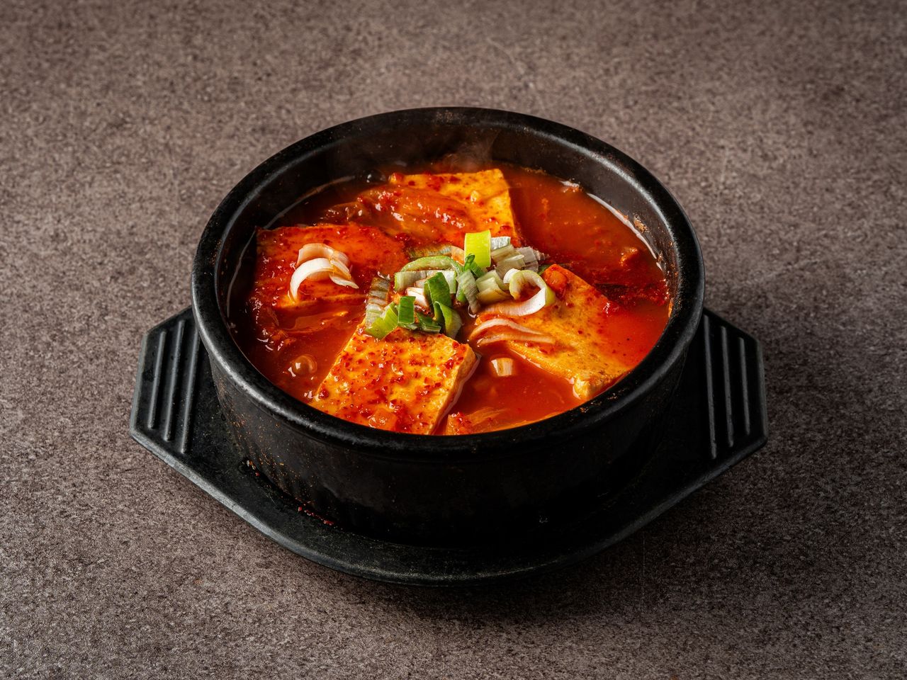 황금돼지 메뉴 촬영 - 어두운 배경 위 검은 뚝배기 김치찌개