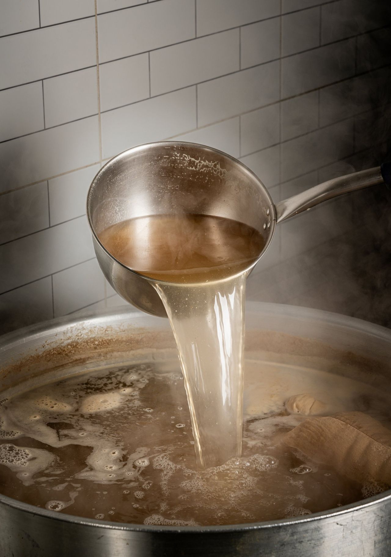 중봉칼국수 포스터 촬영 - 흰 타일 벽 앞 대형 솥에 국자로 육수를 붓는 주방 컷