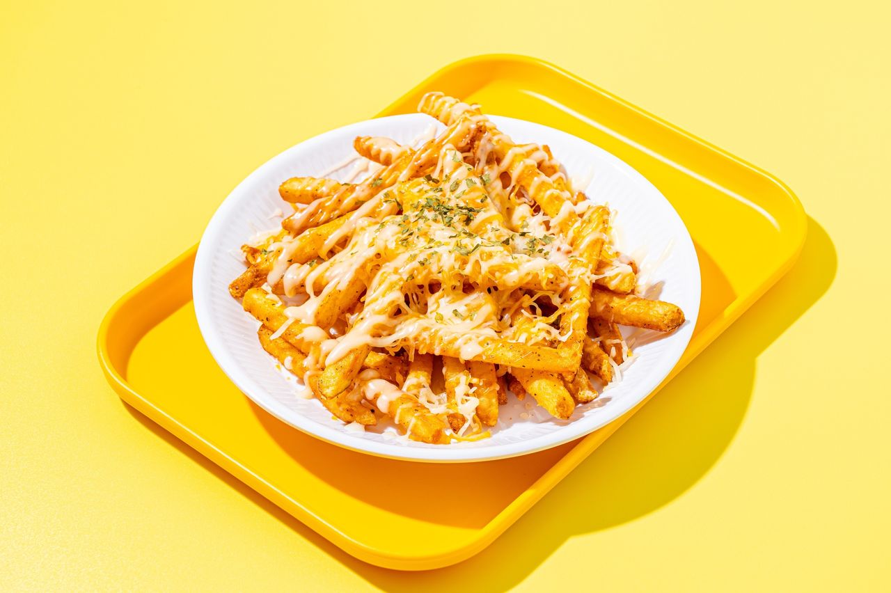 치킨크러싱 배달음식 촬영 - 흰 접시에 치즈 소스를 뿌린 감자튀김