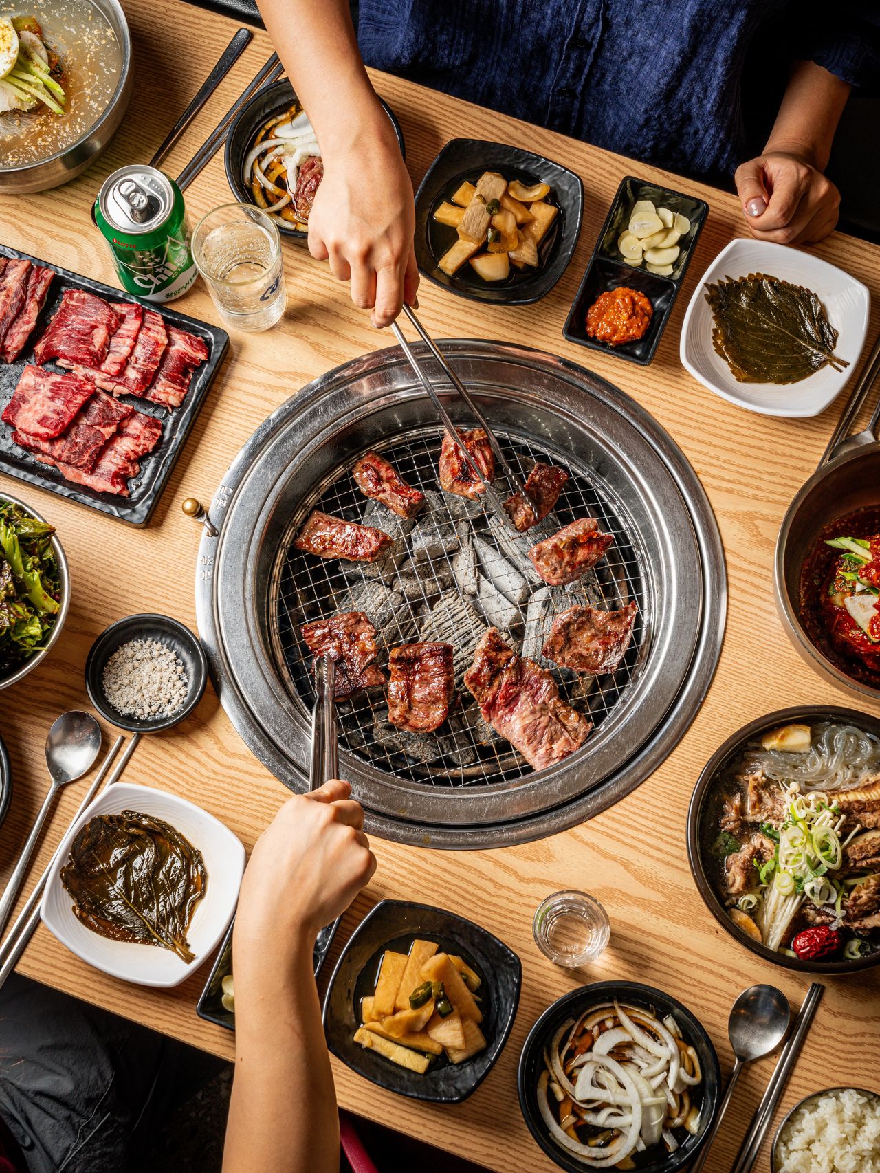 고기집 연출 촬영 - 같은 탑뷰를 세로로 담아 고기가 노릇하게 익어 가는 석쇠와 반찬 그릇을 보여 주는 컷