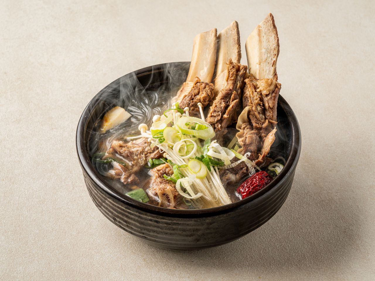 고기집 사이드메뉴 촬영 - 검은 뚝배기에 뼈대 갈비가 선 갈비탕에서 김이 오르는 컷