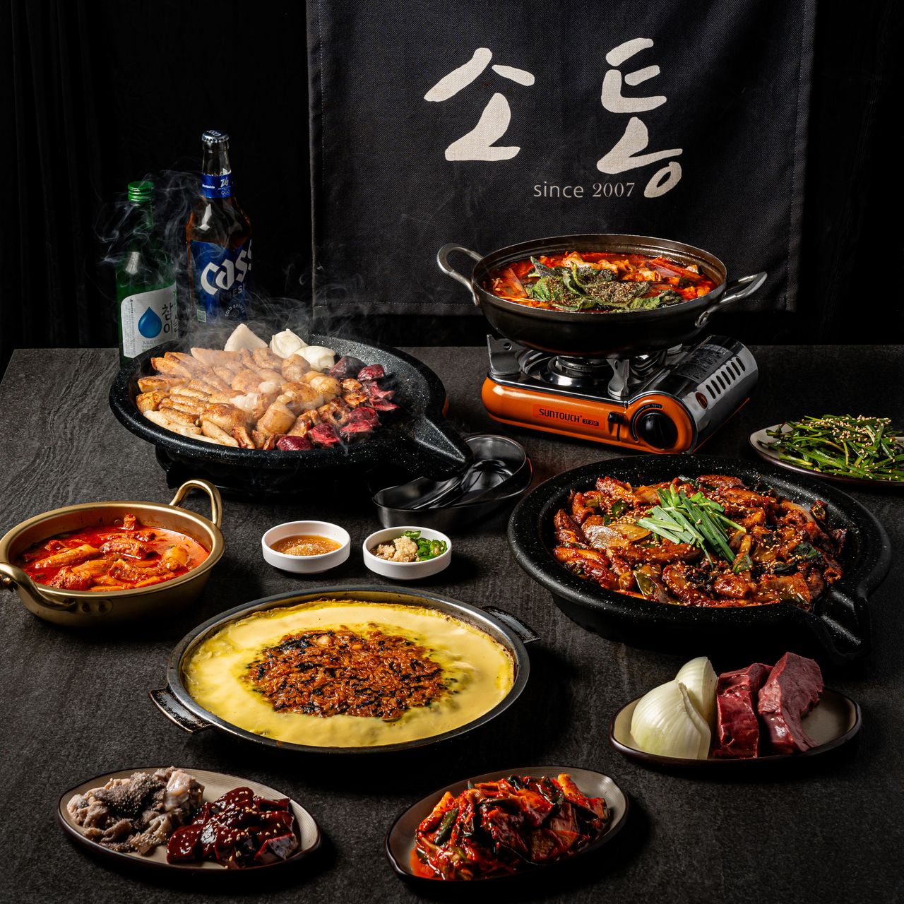 소통한우곱창 연출 촬영 - 매장 로고를 배경으로 곱창과 반찬을 세팅한 상차림 연출컷