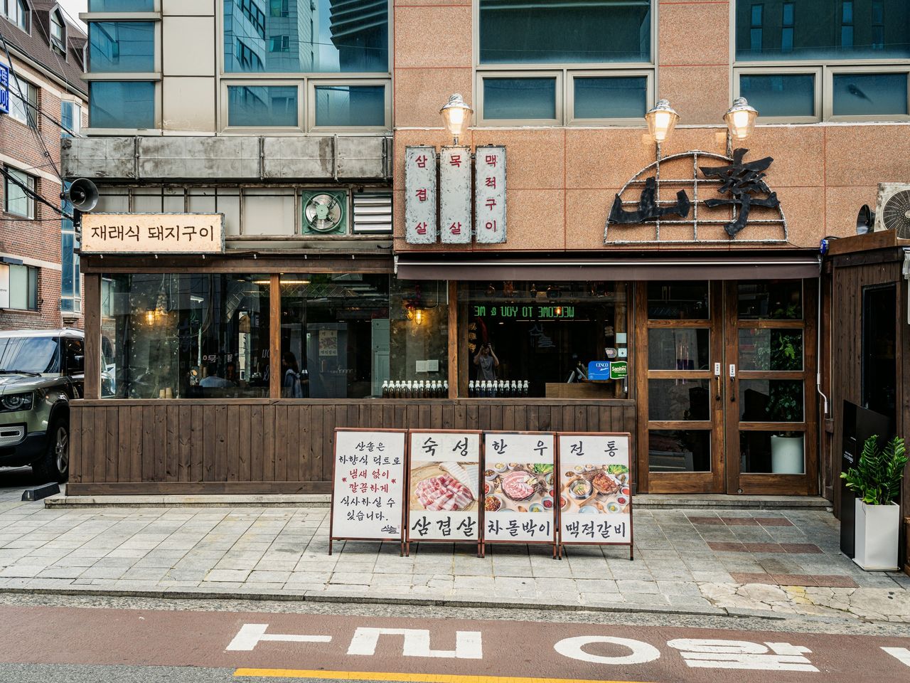 산솔 신사본점 매장 사진 촬영 - 목조 파사드와 입간판 네 개가 늘어선 외관 정면 수평 컷