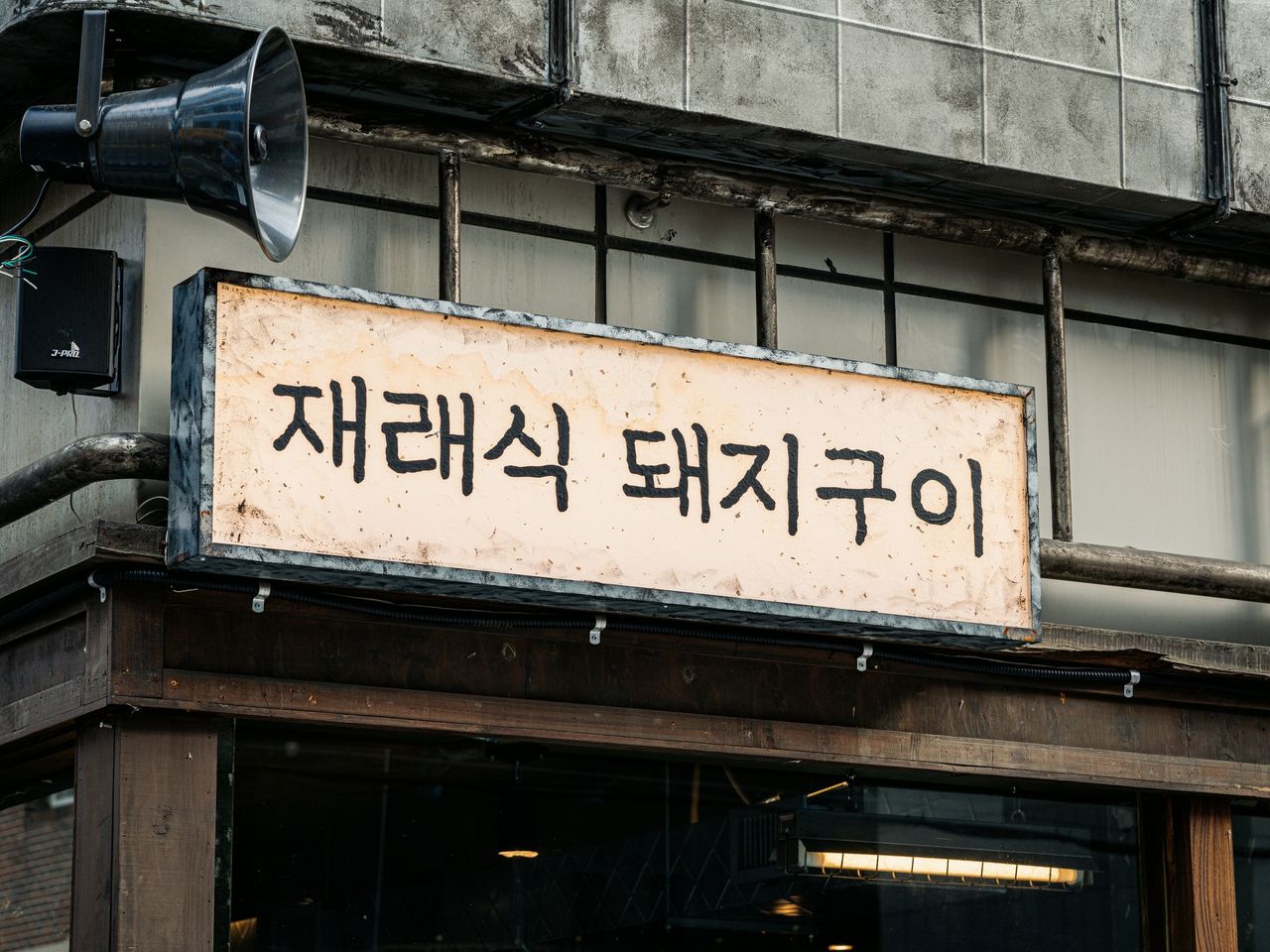 산솔 신사본점 매장 사진 촬영 - 처마 아래 가로로 긴 재래식 돼지구이 간판과 옛 확성기