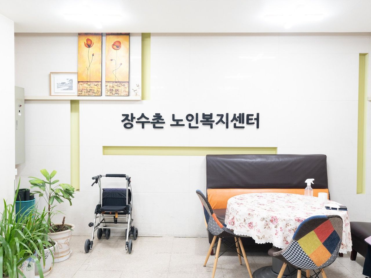 식탁과 소파가 한 공간에 놓인 노인복지센터 거실 — 사람 없이 촬영