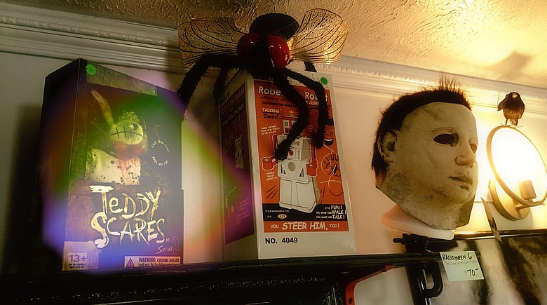 Mike Myers sits comfortably next to toy robots and giant flies