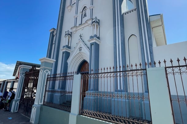 View outside of white and blue Maria Auxiliadora church and surrounding gates in Granada, Nicaragua