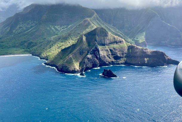 Aerial view of green island surrounded by blue ocean water