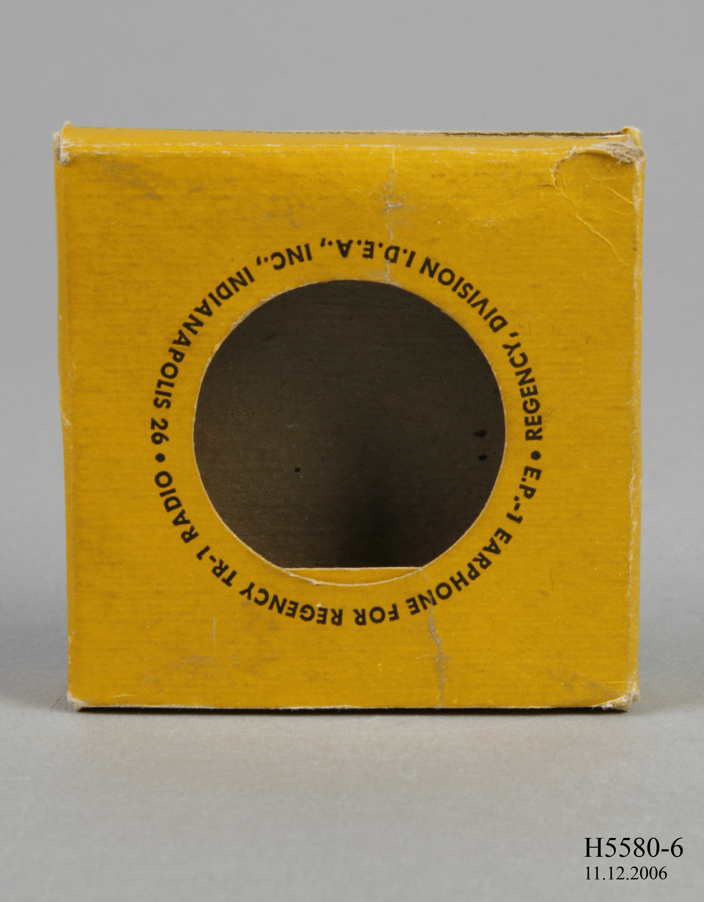 A cardboard yellow box for a Regency transistor radio earphones