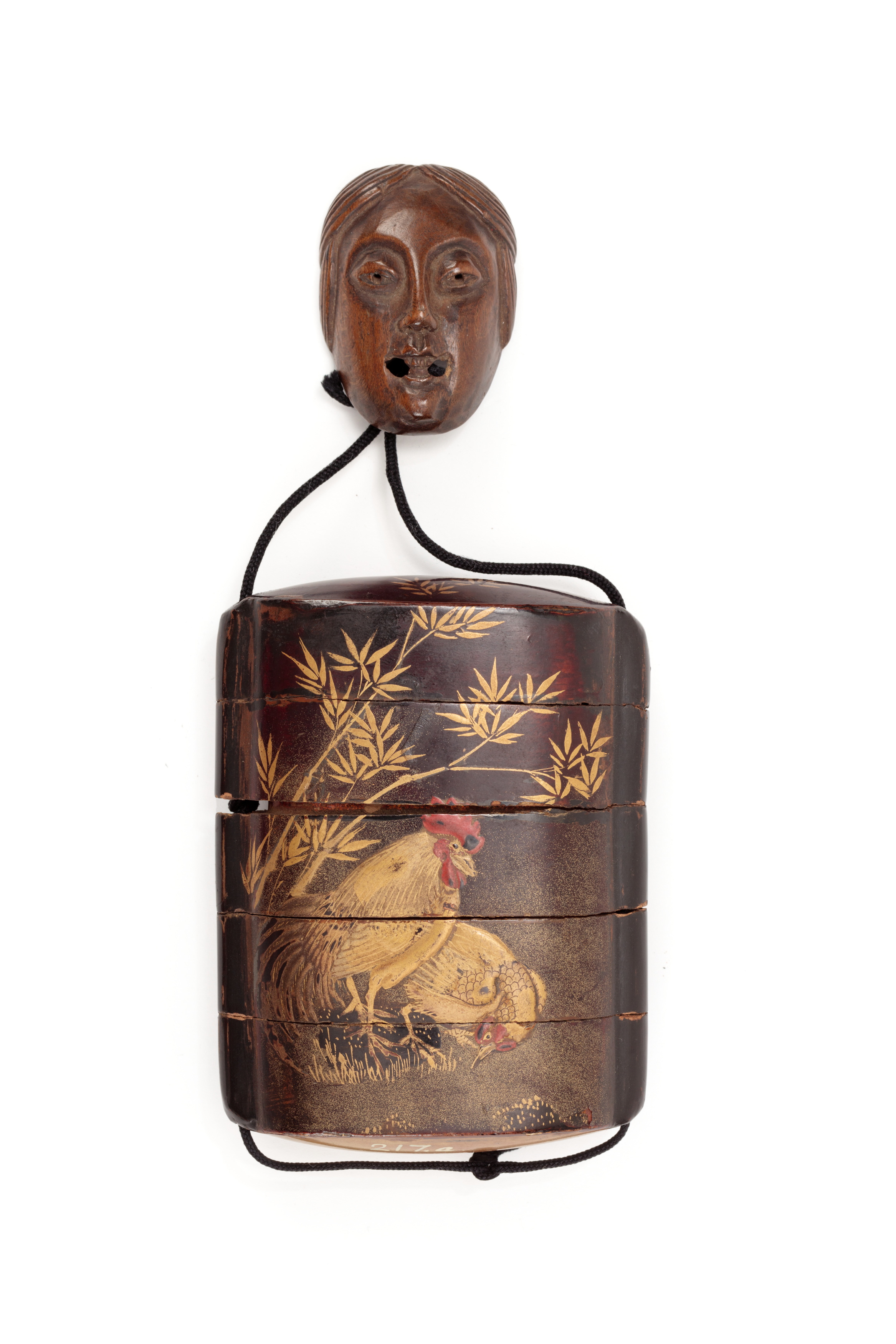 Inro and mask netsuke made from lacquered wood.