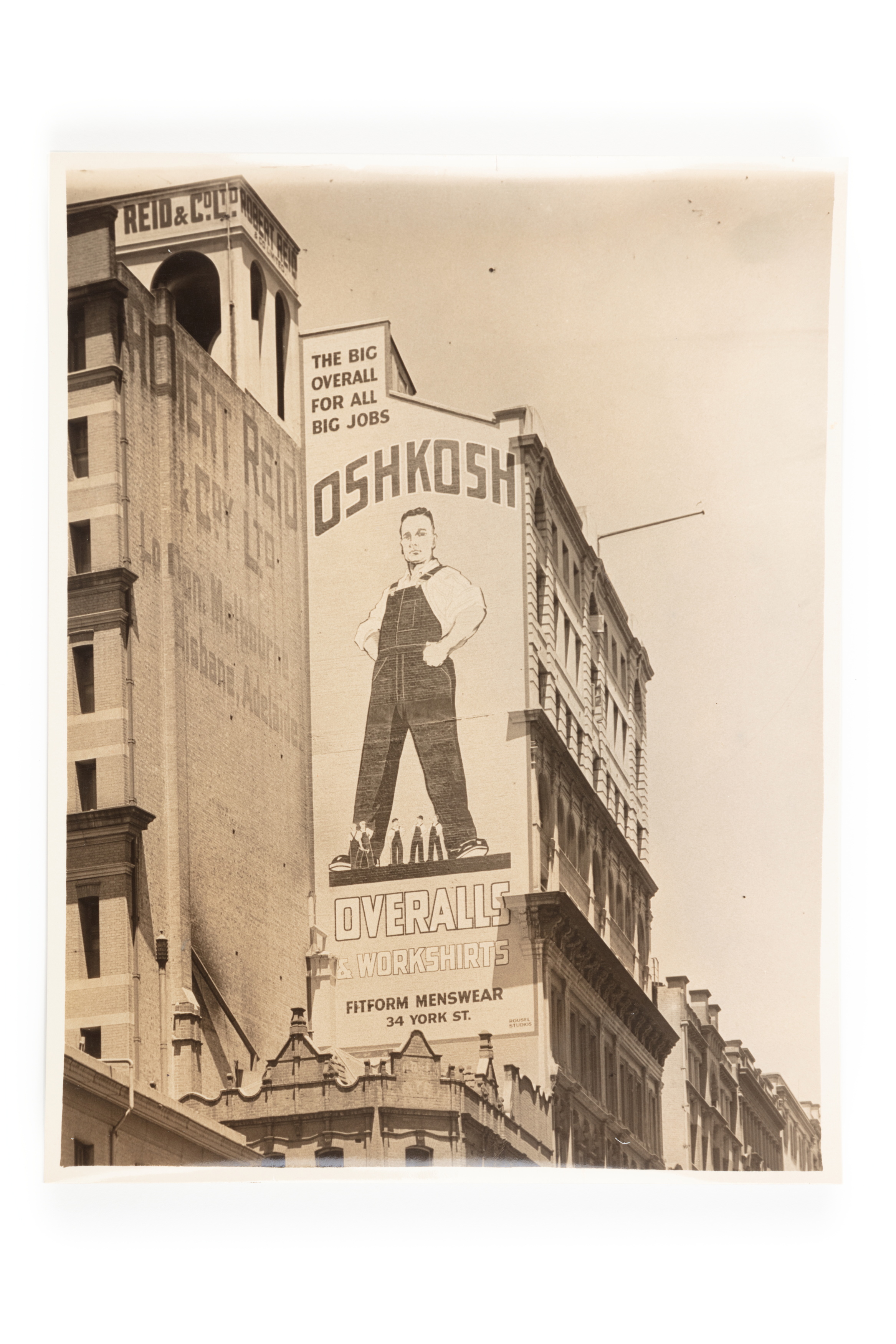Photograph of large wall advertising sign for Fitform Menswear advertising Oskosh overalls and workshirts